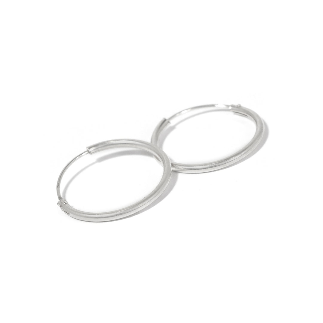 Pair of silver hoop earrings on a white background