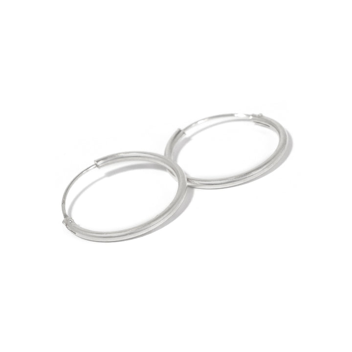 Pair of silver hoop earrings on a white background
