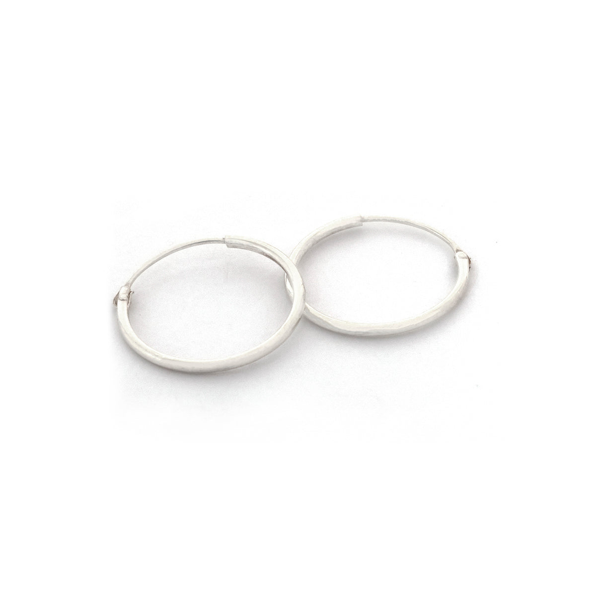 Pair of silver hoop earrings on a white background