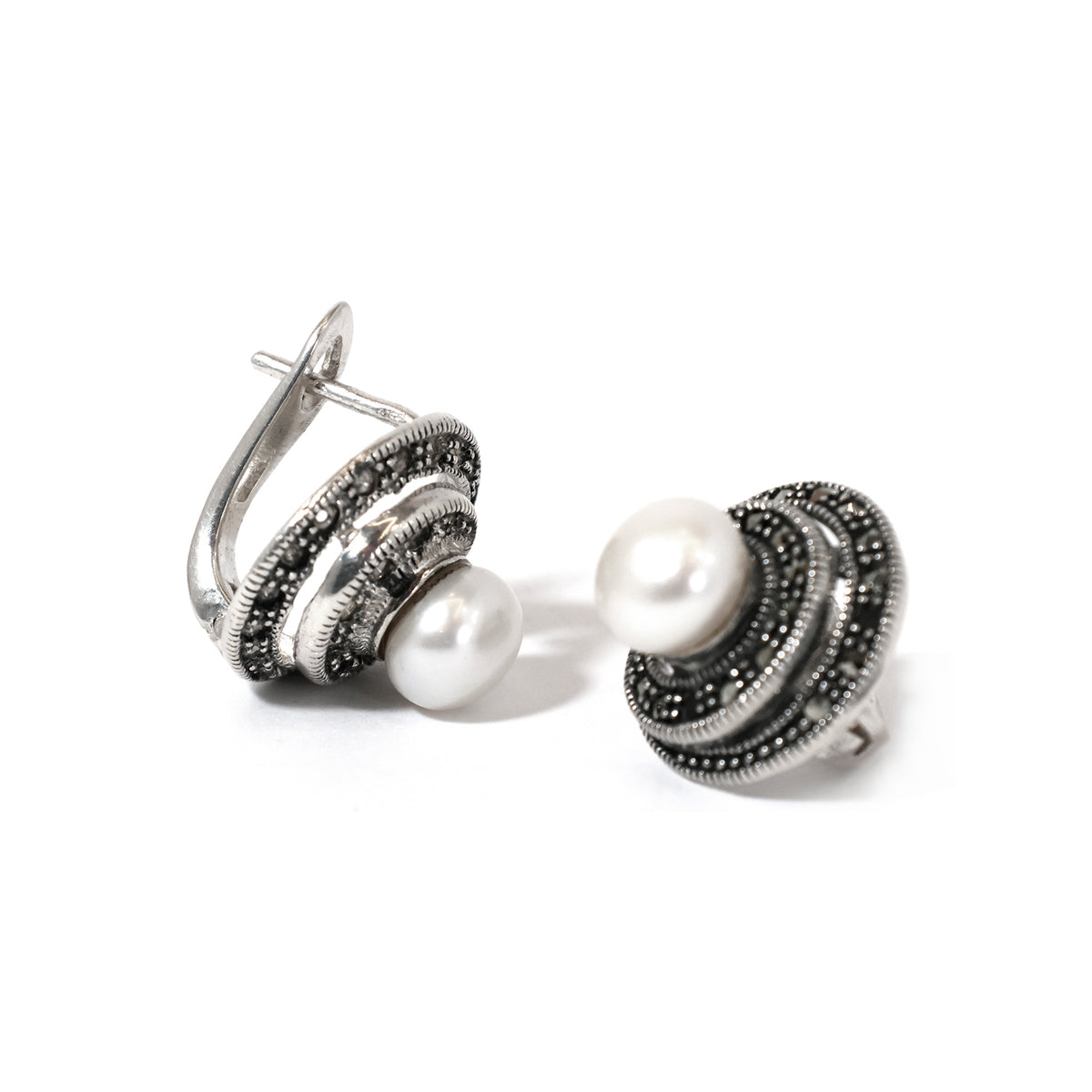 Pair of earrings with pearl-like stones on a white background