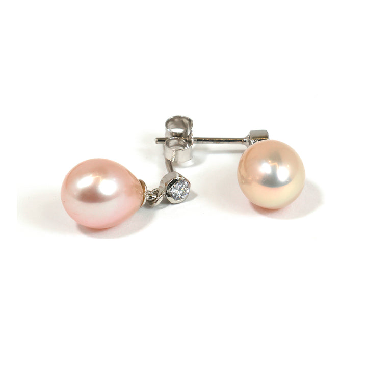 Pair of pearl earrings with a diamond on a white background