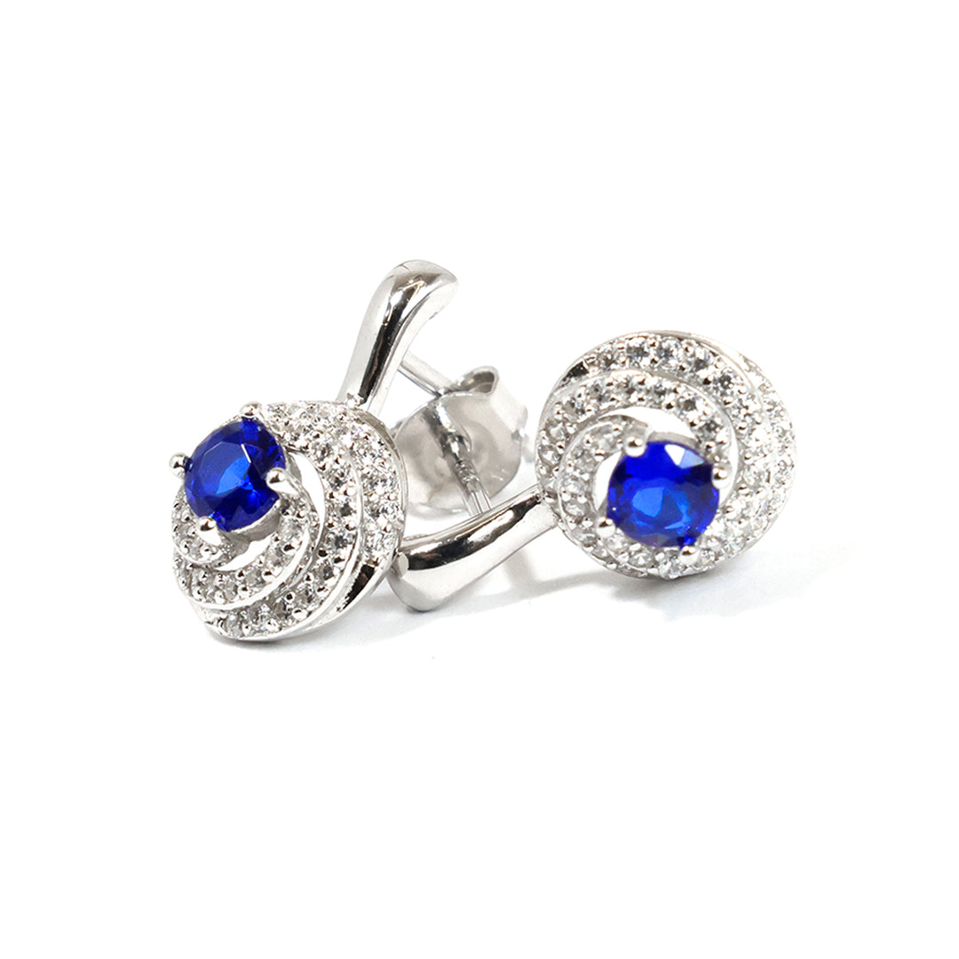 Silver earrings with blue gemstones on a white background