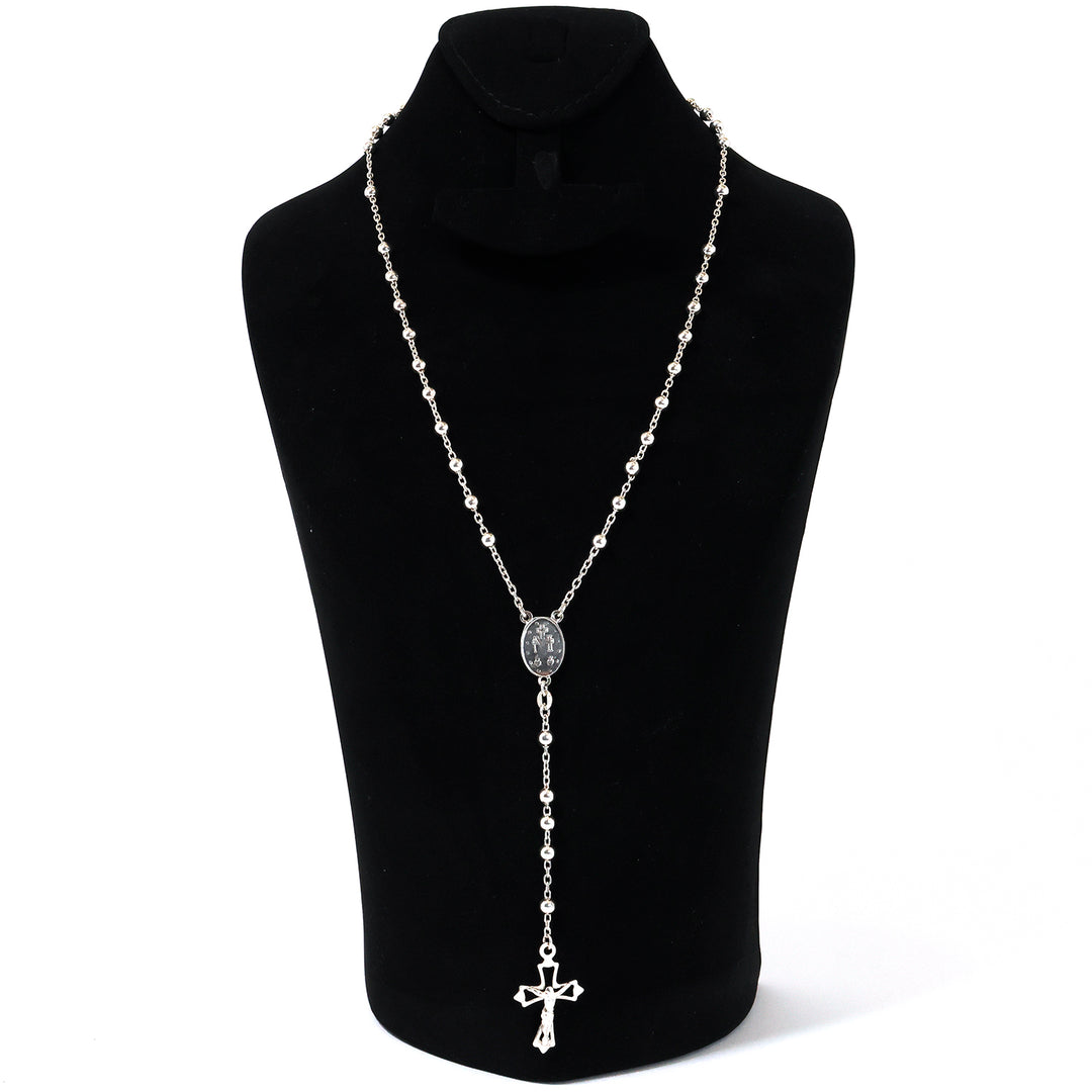 Silver necklace with a cross pendant on a black mannequin against a white background