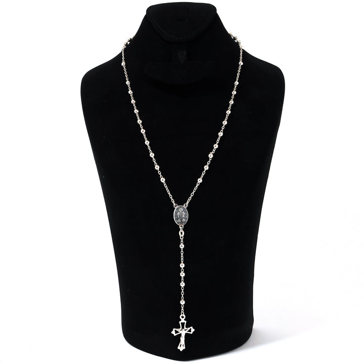 Silver necklace with a cross pendant on a black mannequin against a white background