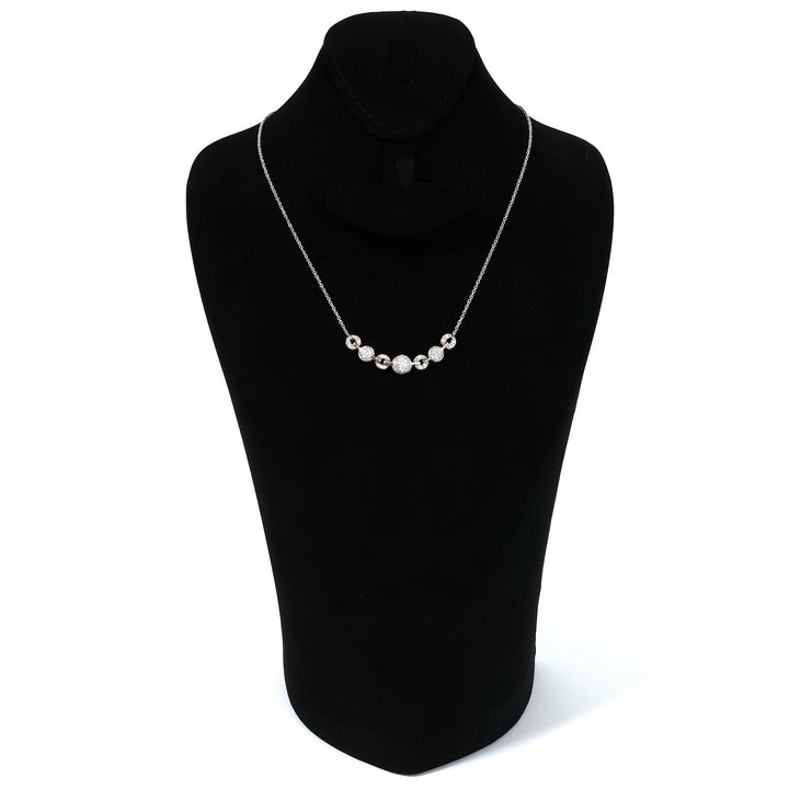 Pearl necklace on a black mannequin bust against a white background