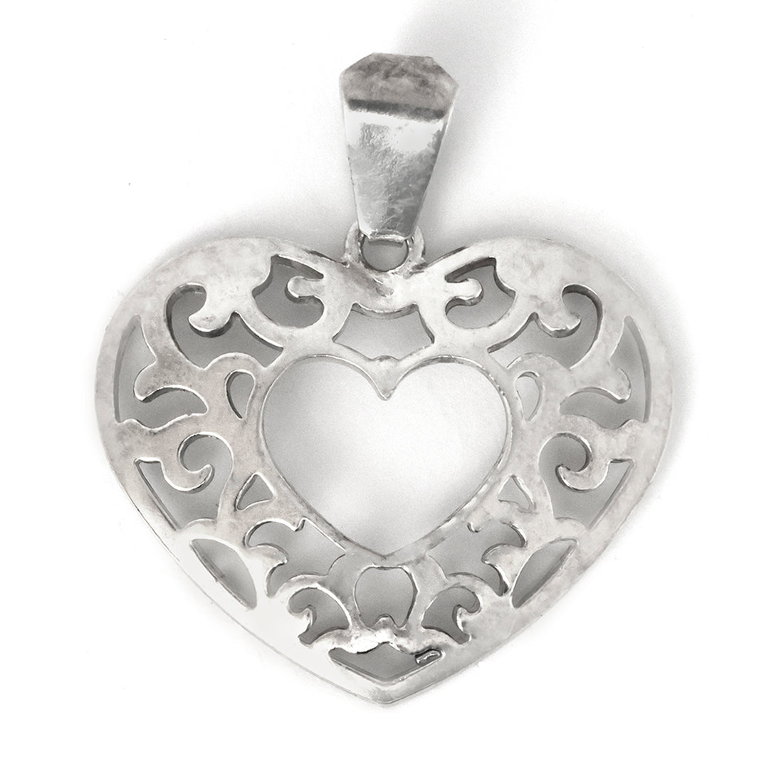 Silver heart-shaped pendant with intricate designs on a white background