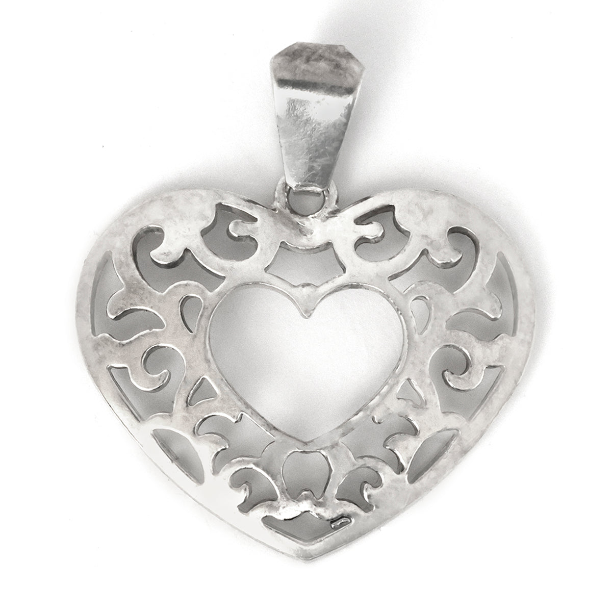 Silver heart-shaped pendant with intricate designs on a white background