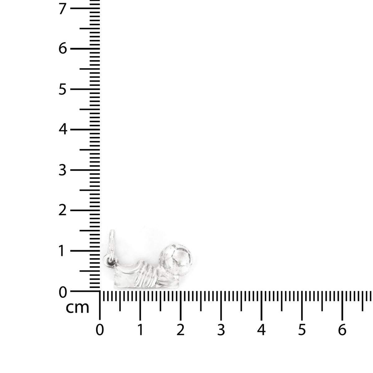 Small silver earring next to a ruler for scale on a white background