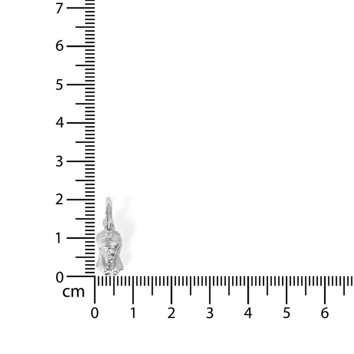 Silver Buddha pendant next to a ruler on a white background
