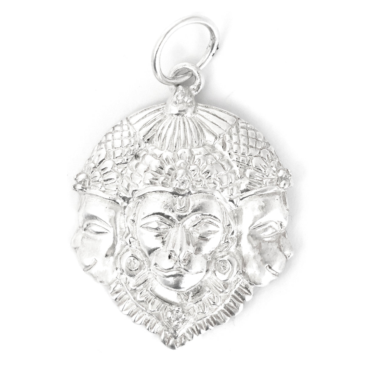 Silver pendant with face design on a white background