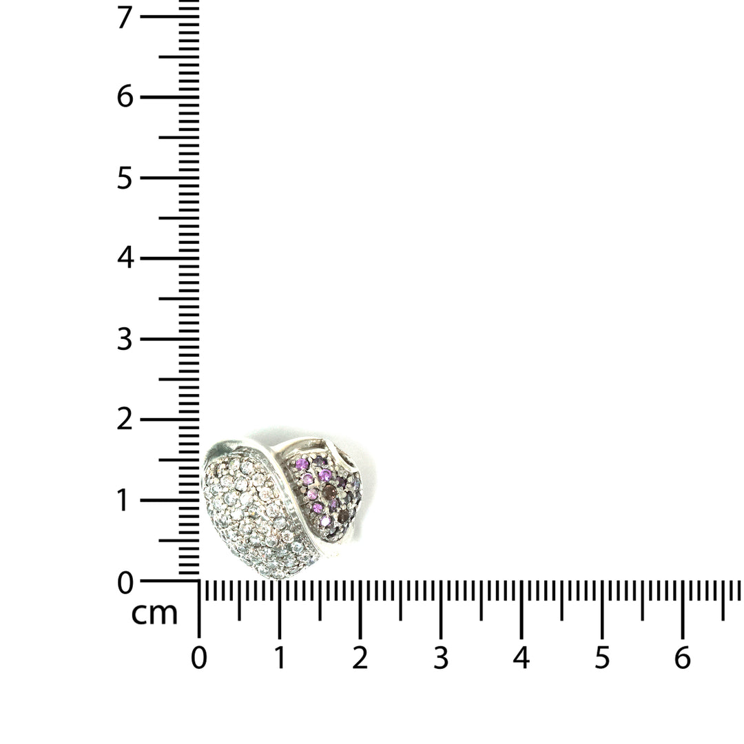 Two heart-shaped jewelry pieces with embedded stones next to a ruler for scale on a white background.
