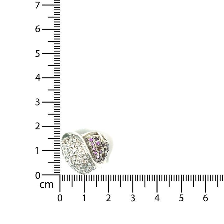 Two heart-shaped jewelry pieces with embedded stones next to a ruler for scale on a white background.