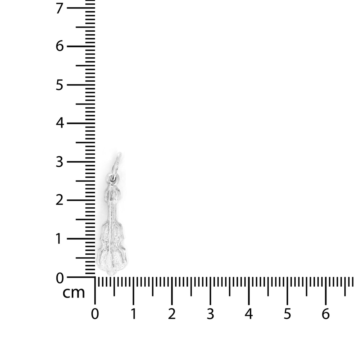 Silver earring next to a ruler for scale on a white background