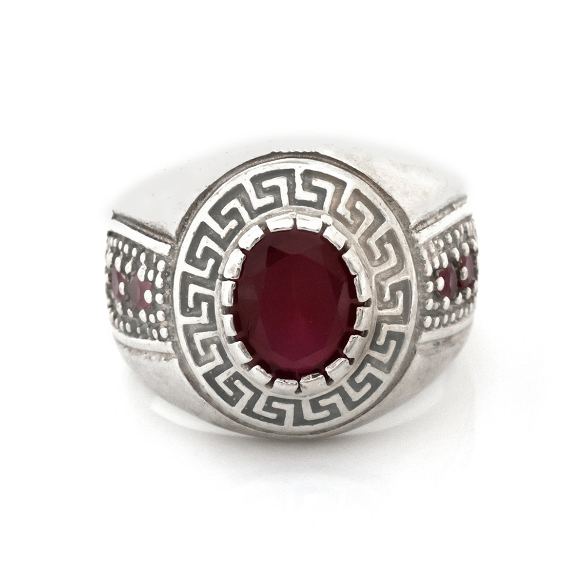 Silver ring with a red gemstone on a white background