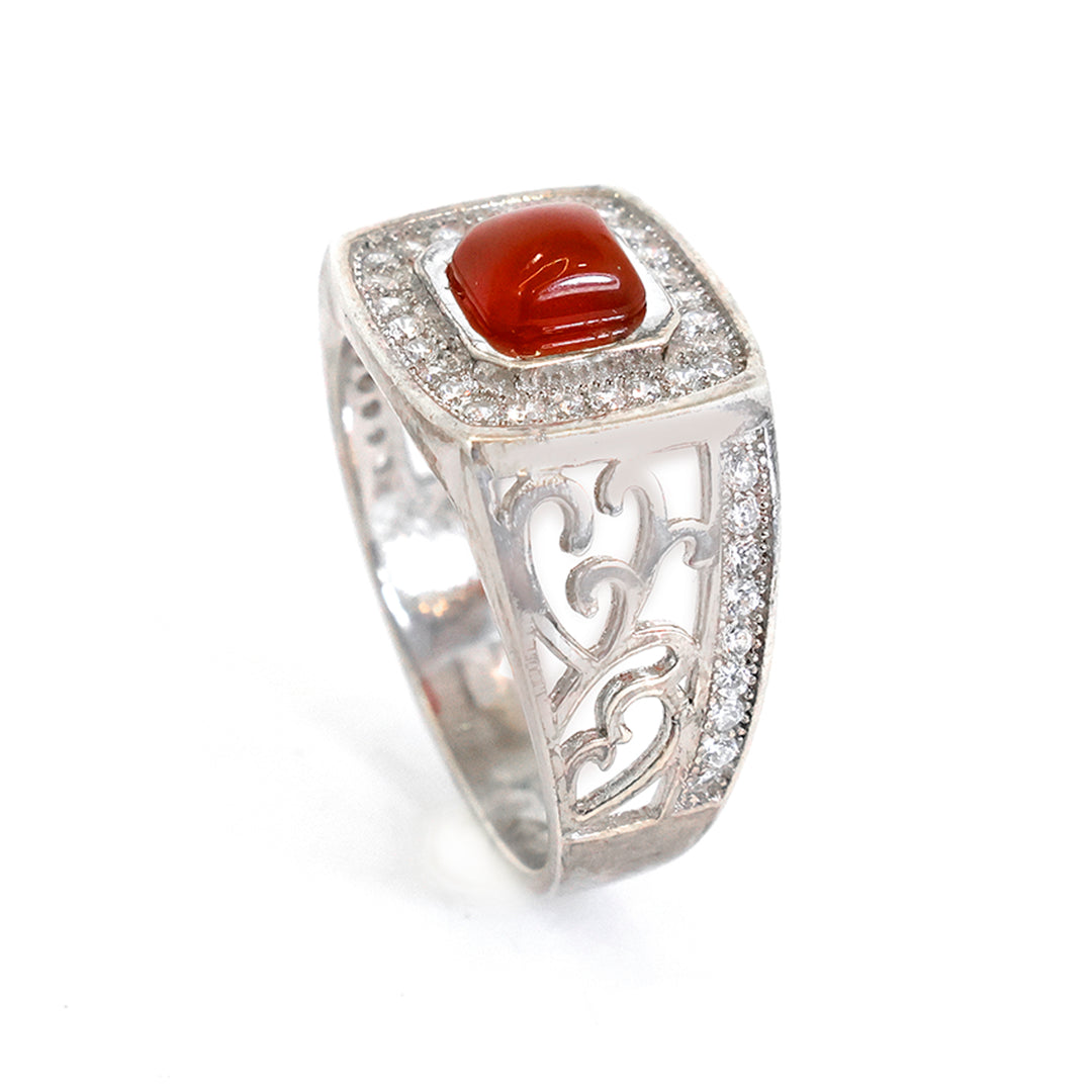 Silver ring with a red stone on a white background
