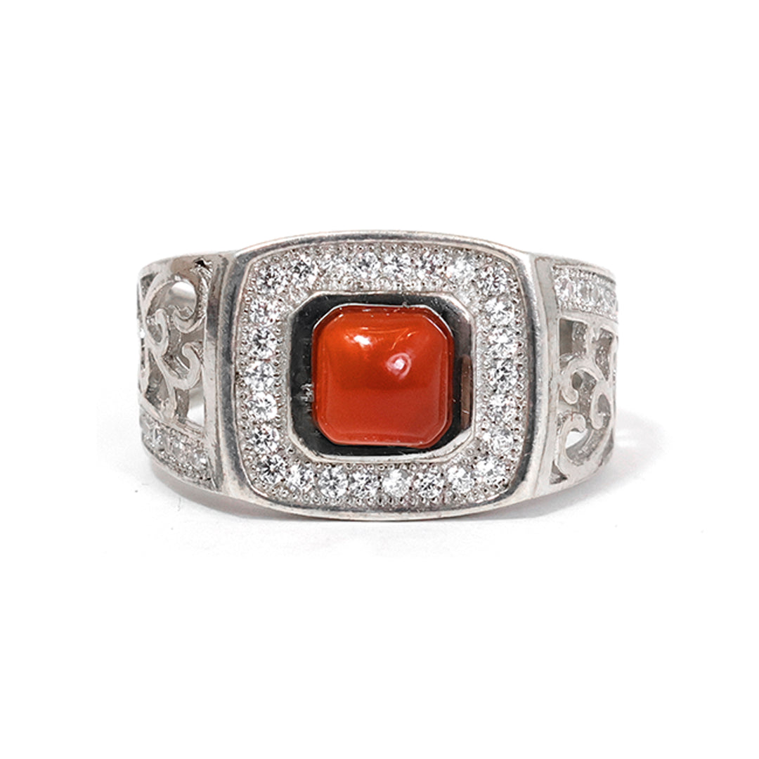 Silver ring with a red stone on a white background