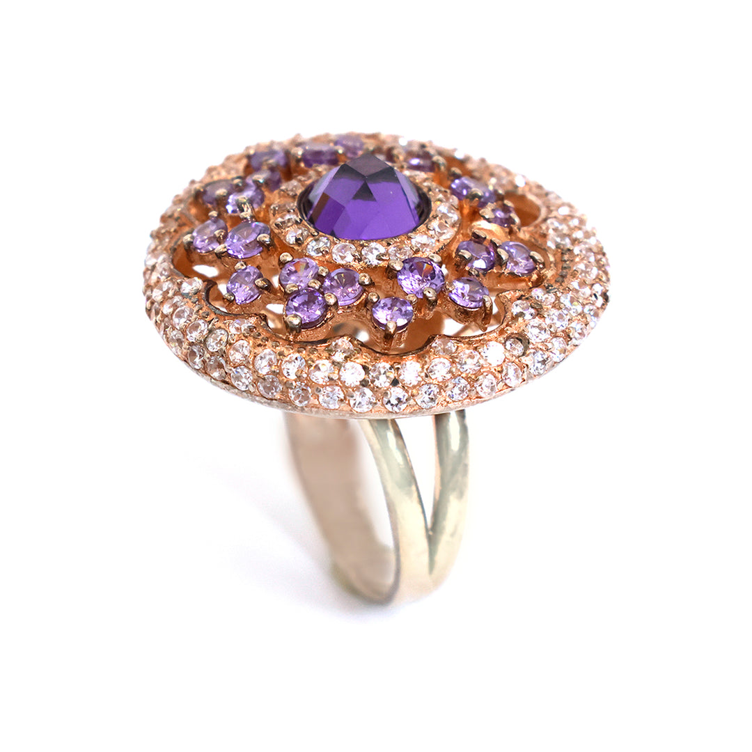 Elegant ring with purple gemstone and rose gold accents on a white background