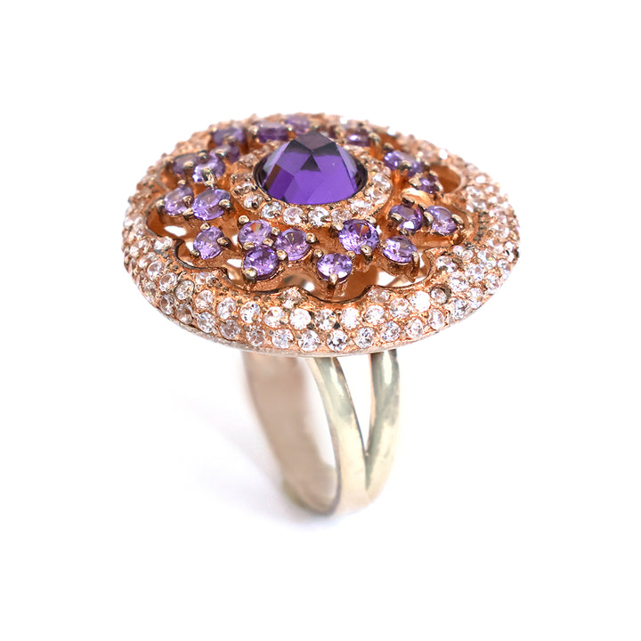 Elegant ring with purple gemstone and rose gold accents on a white background