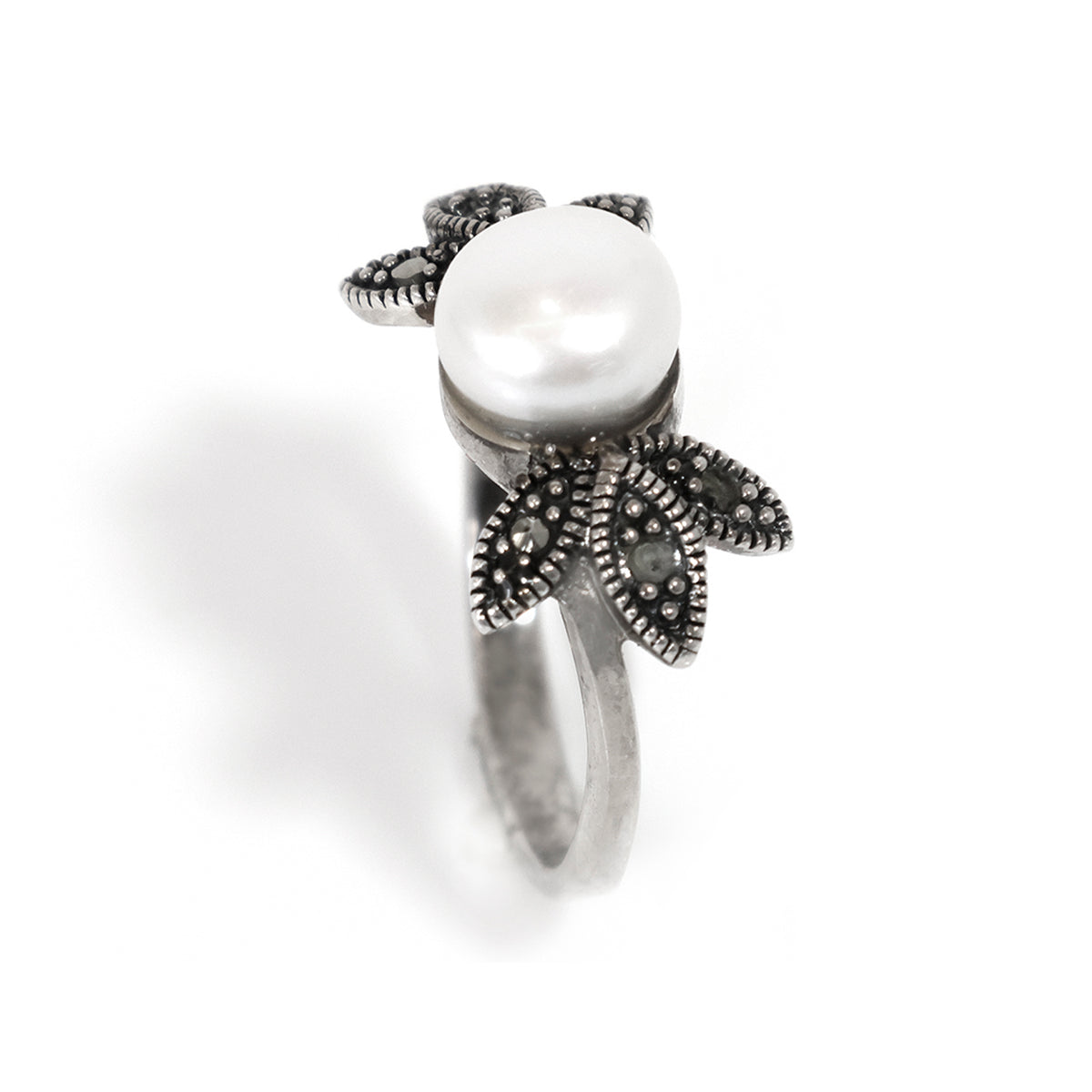 Silver ring with a pearl and floral design on a white background