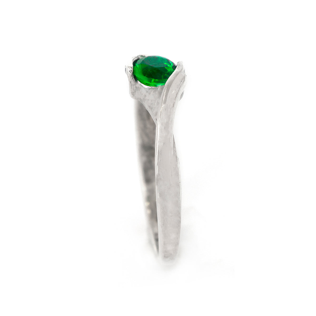 Silver ring with a green gemstone on a white background