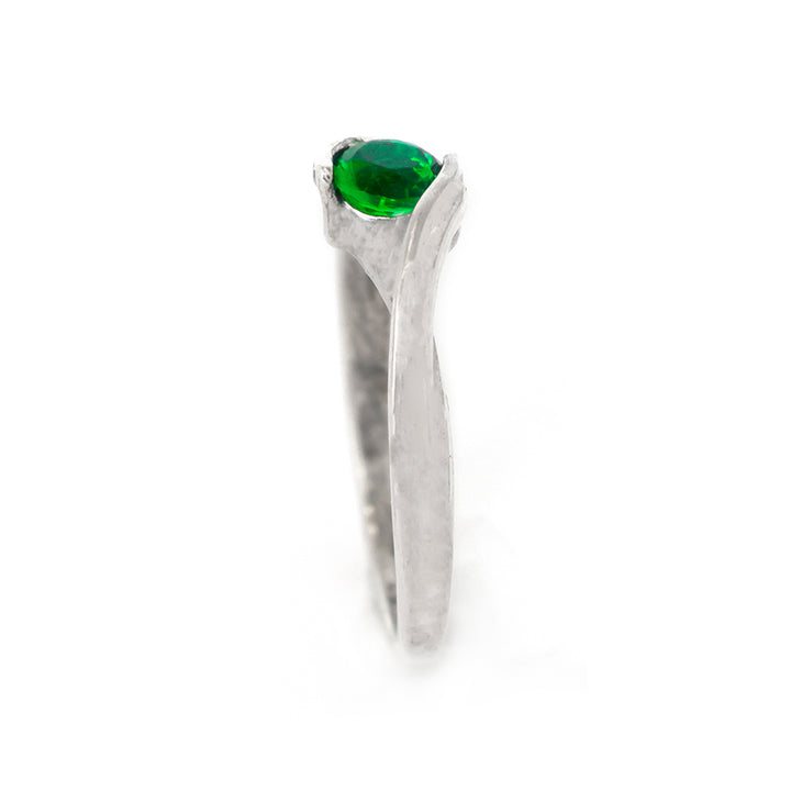 Silver ring with a green gemstone on a white background