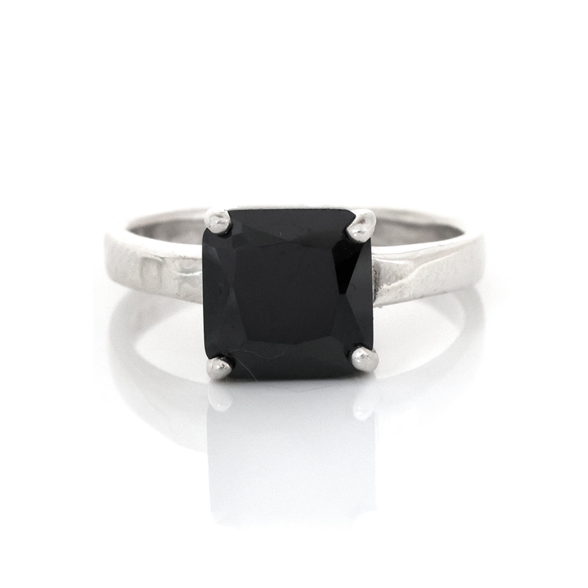 Silver ring with a black gemstone on a white background