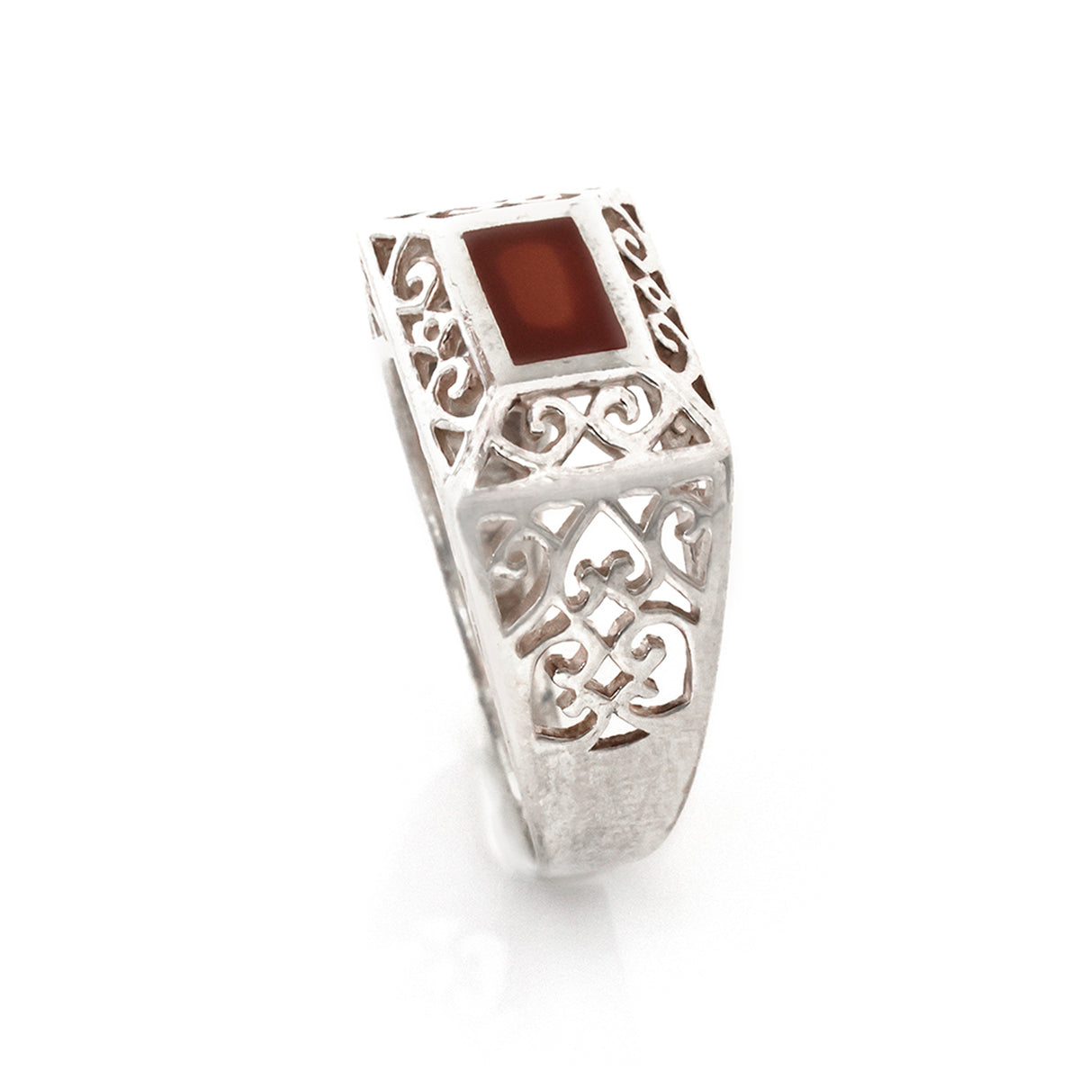 Silver ring with a red stone on a white background