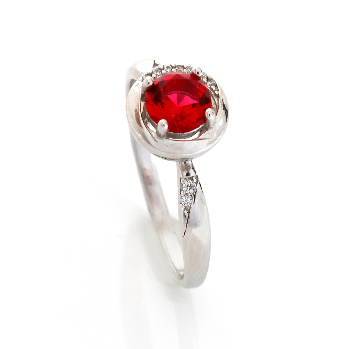 Silver ring with a red gemstone on a white background
