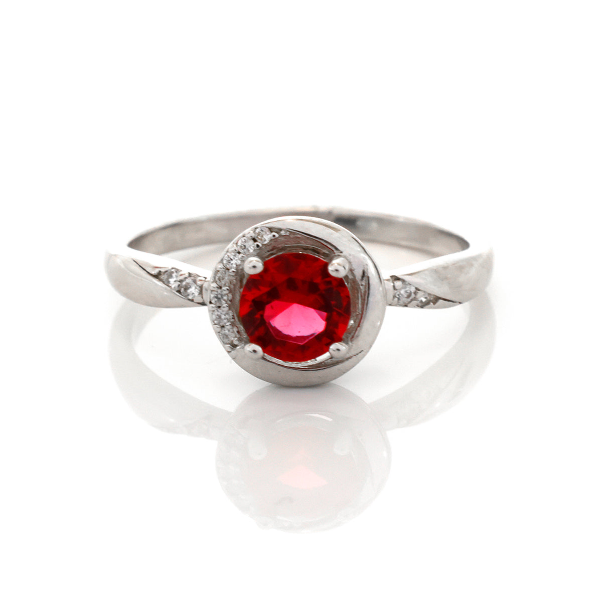 Silver ring with a red gemstone on a white background