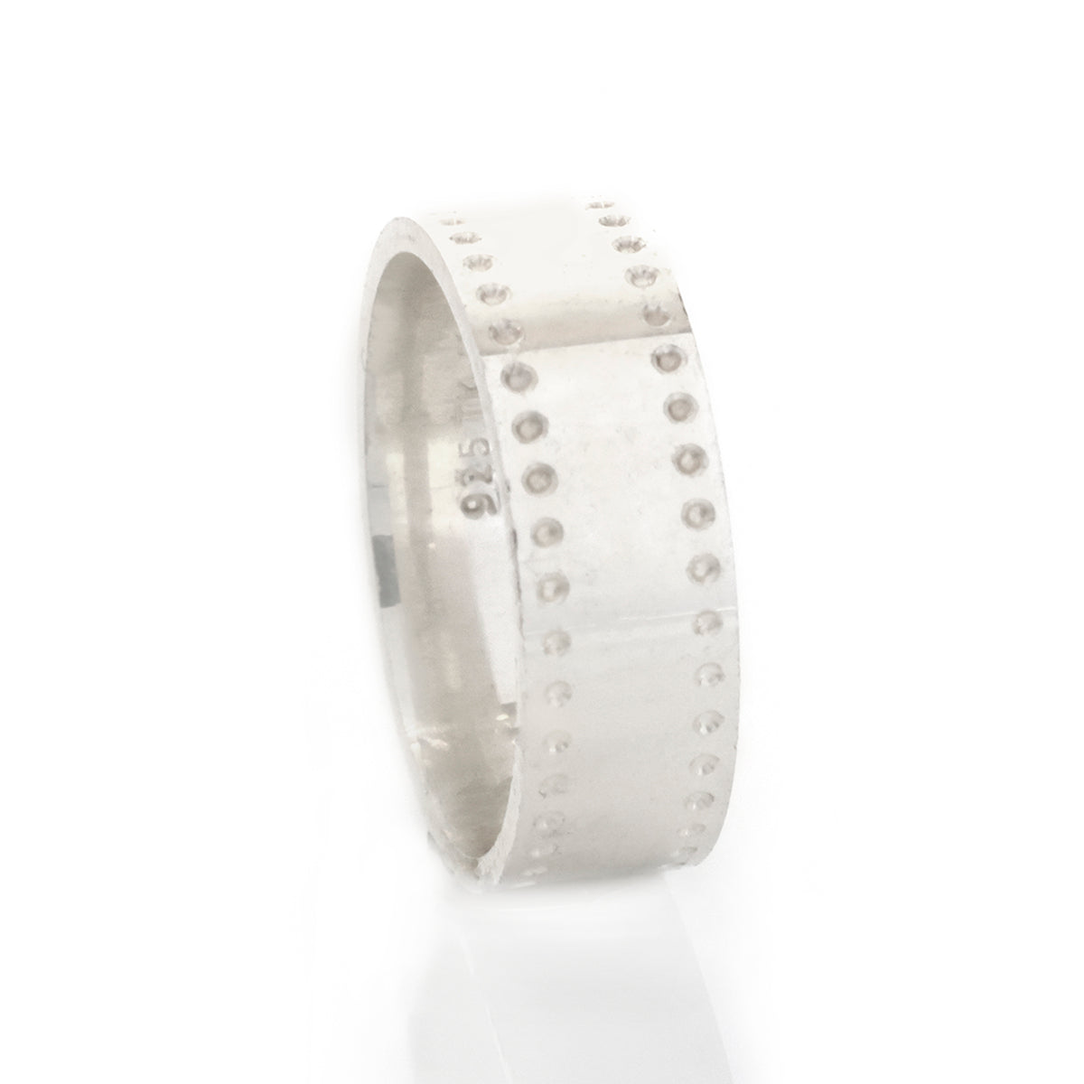 Silver ring with embedded stones on a white background